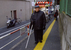視覚障害者の方が歩道を歩いている写真
